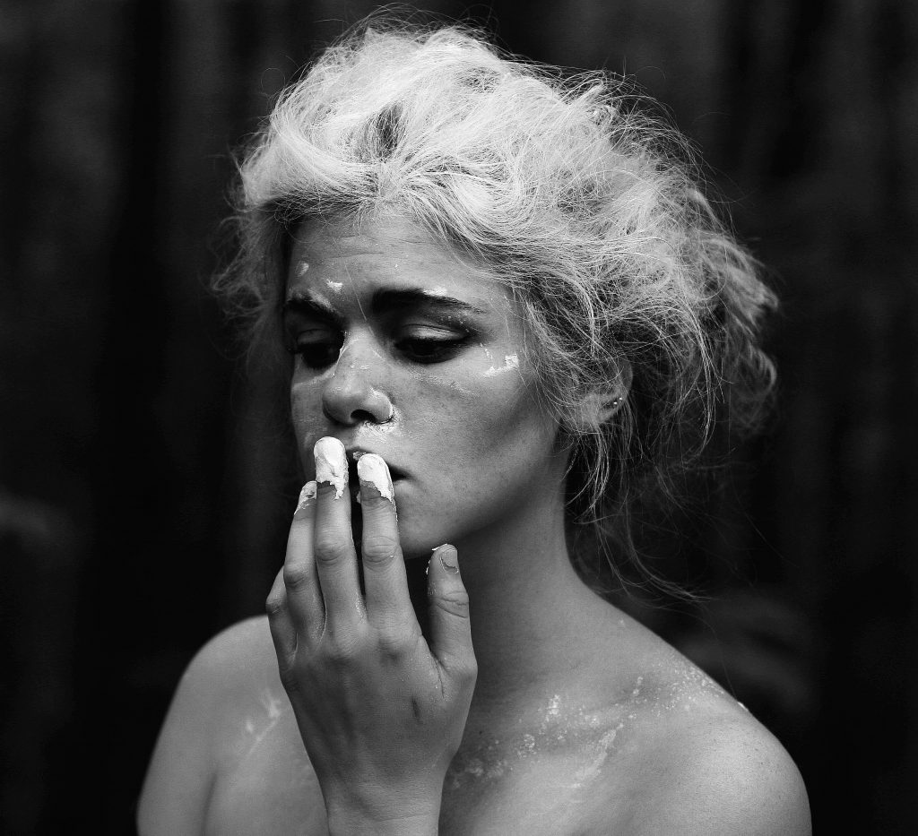 an image of a woman with makeup and a cigarette in her mouth